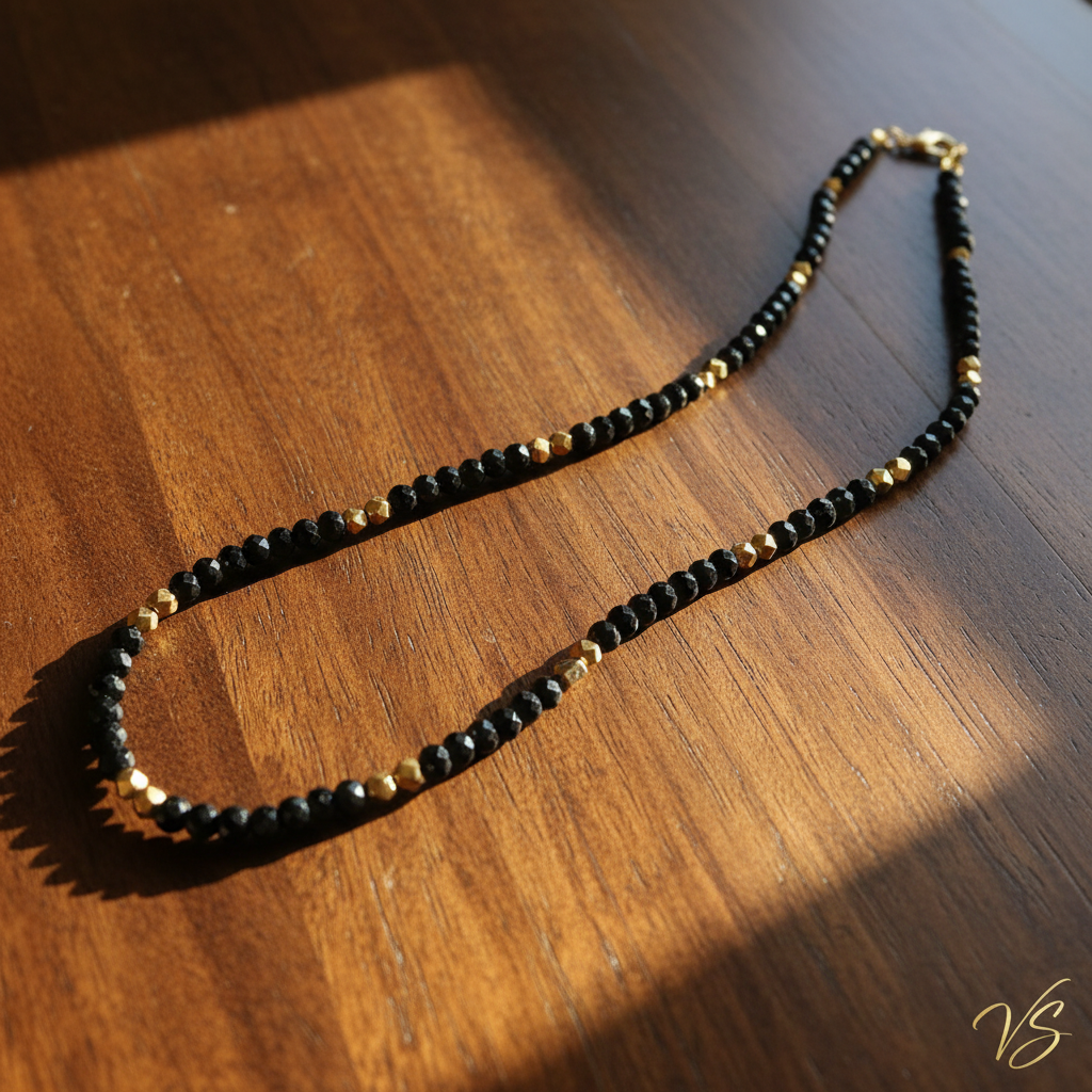Midnight Gold Beaded Necklace σε τραπέζι με ηλιαχτίδες και υπογραφή VS